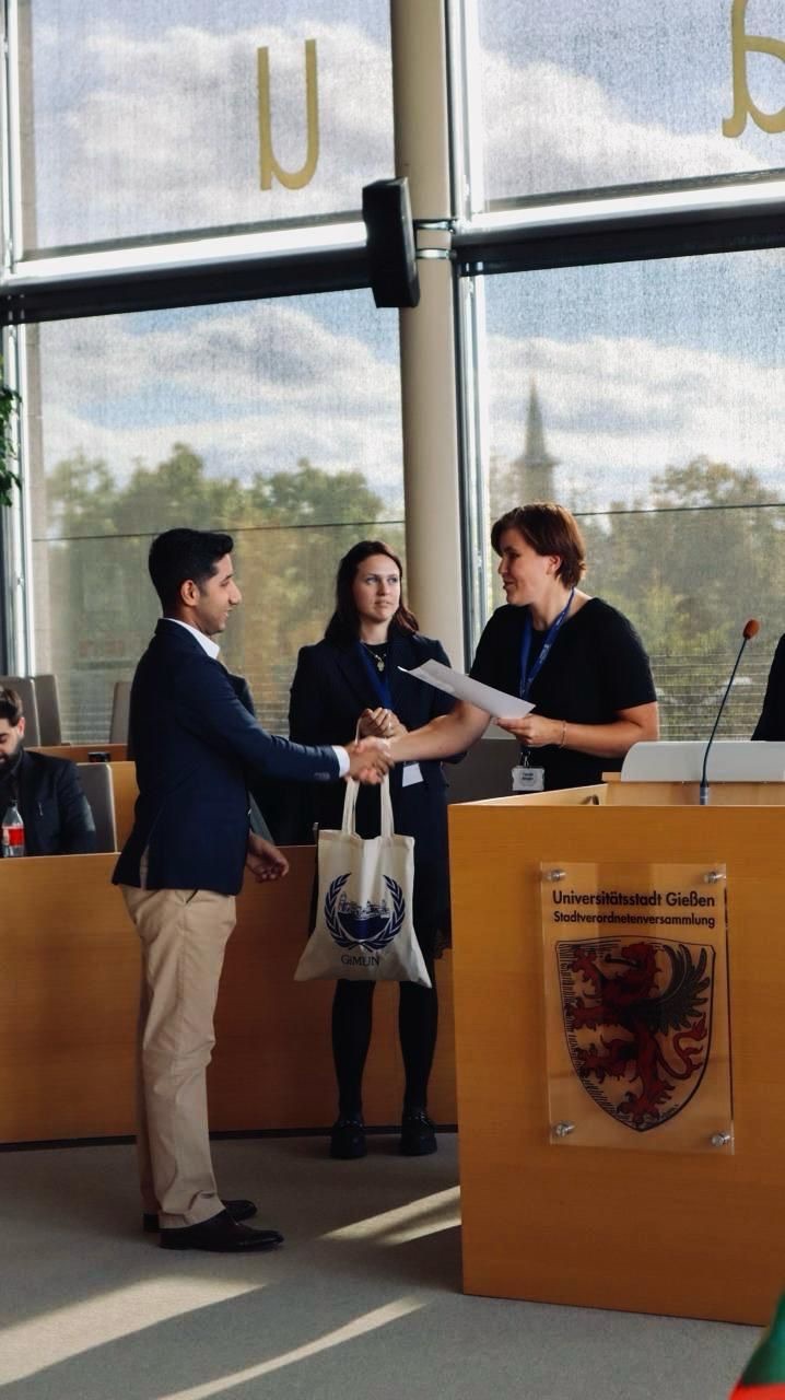 Faizan shaking hands and receiving a certificate in the Gießen council chamber